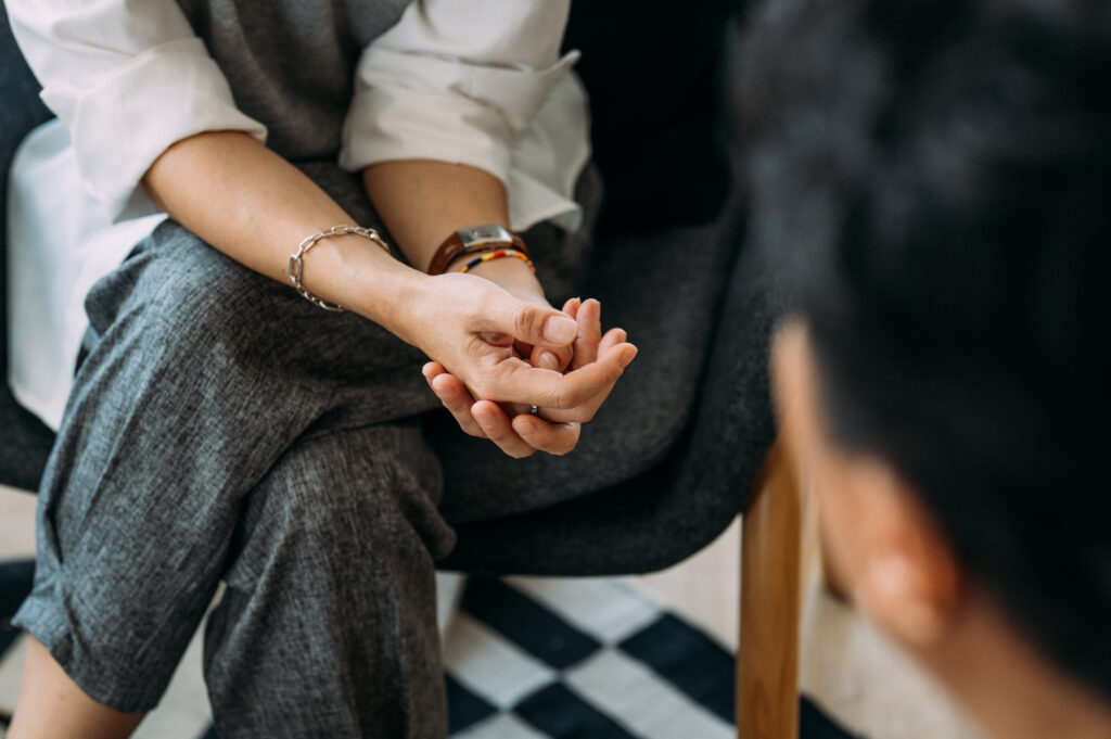 Close-up of woman's hands during counseling meeting with a professional therapist.